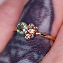 Load image into Gallery viewer, Flora ring (another modeled view on the artist&#39;s tattooed finger): stunning Songea sapphire (one of a kind) with beautiful rutile and inky inclusions with salt and pepper/gray diamonds (size 5.5 and can be resized complimentary in-house)